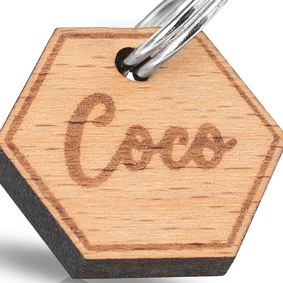 Detalle de chapa hexagonal de madera con nombre grabado para collar de mascotas en modelo Hexa