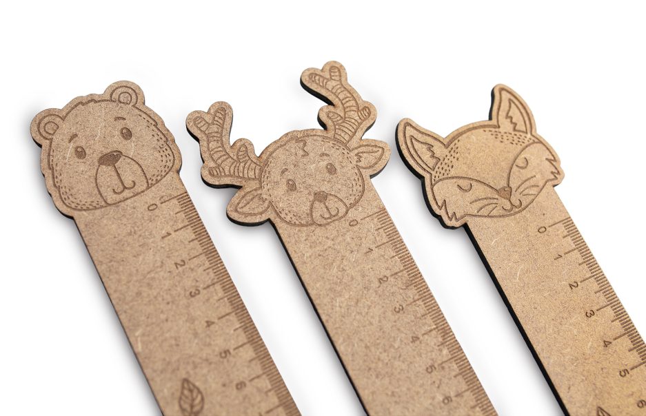 Detalle de parte superior de regla personalizada con dibujo de cabezas de animales del bosque. La primera tiene un oso, la segunda un reno y la tercera un zorro, todas ellas sobre un fondo blanco