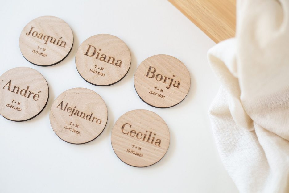 Identificadores de mesa con forma circular y personalizados de madera natural de castaño con nombre y fechas grabados